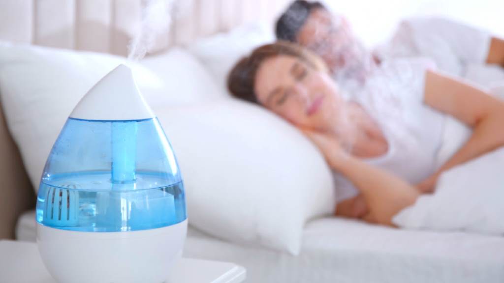 A humidifier releasing mist in a cozy bedroom to combat dry air and static hair