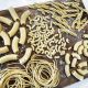 Italy pasta extruder creating perfect rigatoni strands dusted with semolina