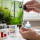 Person using a liquid test kit to check aquarium water quality at home