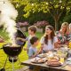 Family gathered around outdoor grill enjoying backyard barbecue meal together