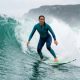 Woman wearing secure surfing swimsuit riding heavy waves