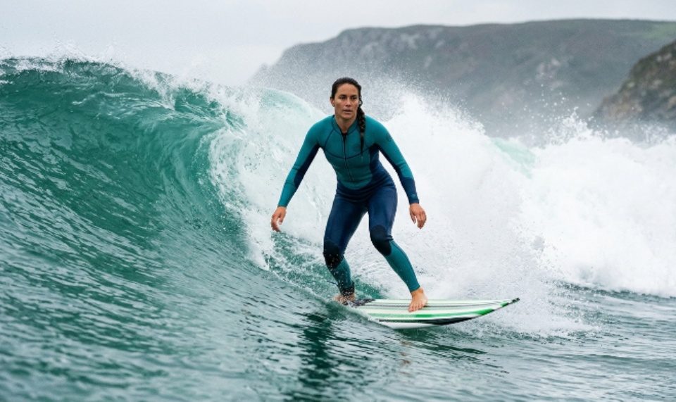 Woman wearing secure surfing swimsuit riding heavy waves
