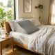 White memory foam wedge pillow resting on a modern bed with soft linen sheets.
