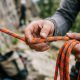 Climber inspecting a durable budget rappel rope on a Texas cliff edge.