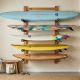 Organized surfboards mounted on horizontal wall racks in a clean garage.