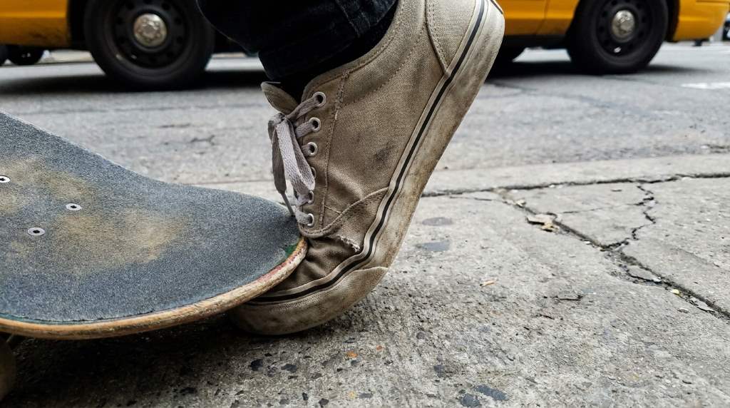 Skateboarder checking toe space inside skate shoes before riding
