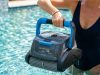 Robotic pool cleaner scrubbing the floor of a modern residential swimming pool