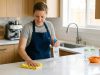 Parent sanitizing kitchen counter before preparing baby food.